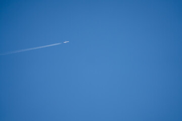 high altitude twin engine contrails (jet airplane vapour trails) across a deep blue clear sky