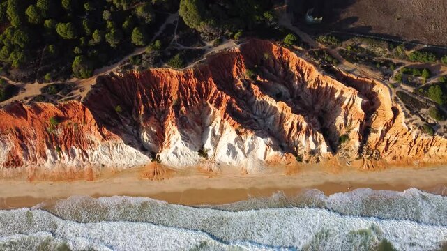 Falesia Beach, Algarve, Portugal. Golden mile beach with orange rocks, golden sand and turquoise sea. Aerial drone perspective Famous travel destination in south of Portugal. Drone backwards tilt up