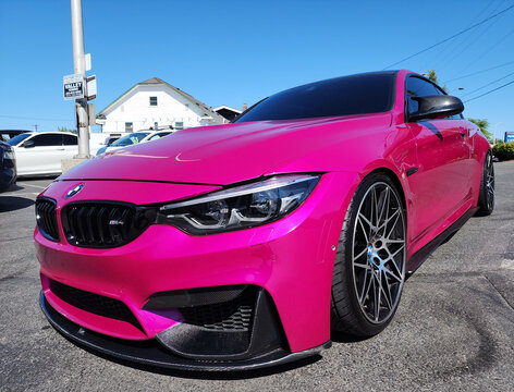 Seattle, WA, USA -July 19, 2024 : BMW F82 M4 Competition pink color corner front view. BMW F82 M4 is the sport version of BMW car.