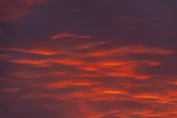 A captivating sky at sunset with dark red and orange clouds, creating a striking and moody atmosphere. The layered clouds add depth and intensity to the scene.