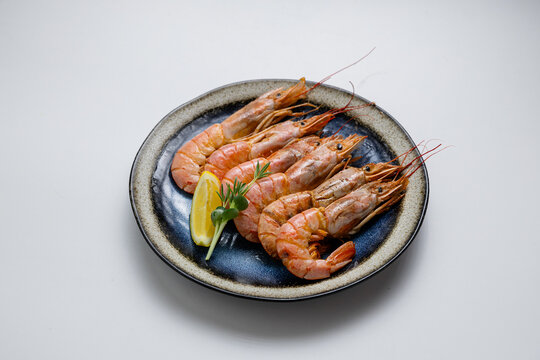 Grilled prawns with herbs and lemon, served on a ceramic plate. Perfect seafood appetizer or meal