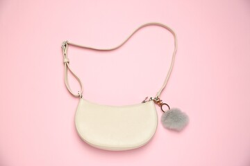 Bag with grey faux fur keychain on pink background, top view