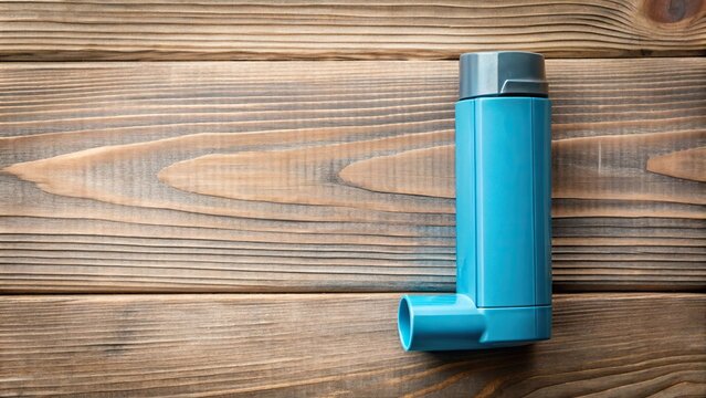 Blue asthma inhaler on wooden background