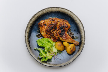 Juicy roasted chicken with black pepper, grilled potatoes, and fresh greens, elegantly plated