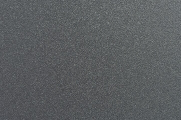 Textured black surface with fine grains reflecting light