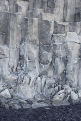 Icelandic rock formations. Black basalt columns. Nature background. Black sand beach with rock cliff. Close up