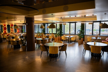 Elegant restaurant interior with natural light, cozy decor, and stylish table settings