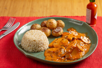 chicken with sauce, rice and potatoes