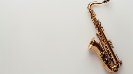 A golden saxophone rests on a white surface