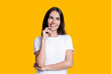 Dreamy young woman with brunette hair. Stylish female. Female casual style. Portrait of millennial girl. Caucasian millennial girl. Woman in white tshirt isolated on yellow. Capturing personality