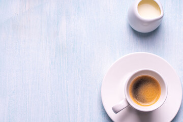 Espresso coffee cup and milk on a blue background. Top view. Space for text