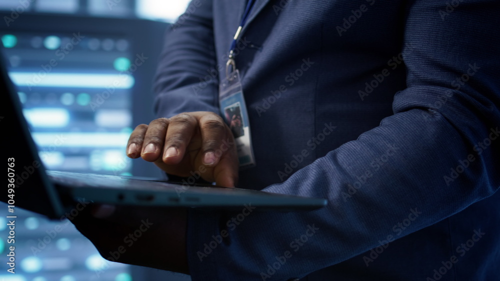 Poster it technician working on notebook in data center, overseeing server operations. extreme close up sho