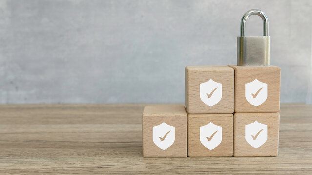 Security Concept: Wooden Blocks with Shield and Checkmark Icons Stacked with Padlock on Top
