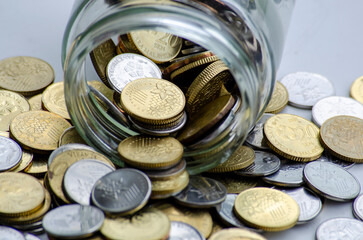 Golden coins and jar represent business, investment or any monetary concept. Customizable space for...