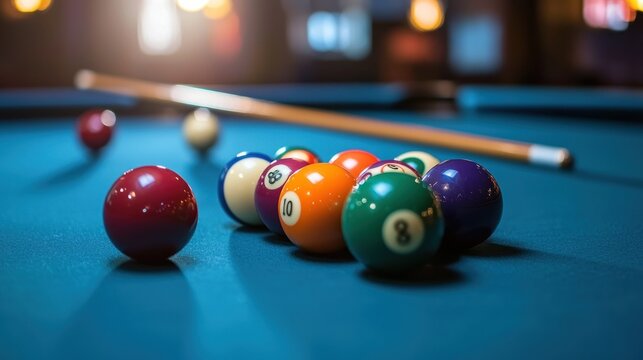 Close-up of a billiard table with a full set of colorful balls and a cue stick