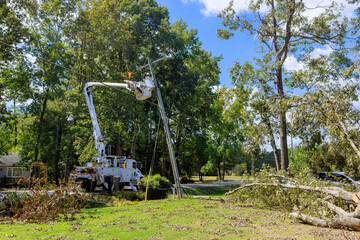 Technician in bucket lift works on an electrical pole under after hurricane