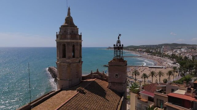 Aerial view of Sitges coastal village and Iglesia de San Bartolome y Santa Tecla during a sunny day