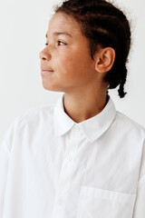 Young boy in white button down shirt gazing off into the distance with a trendy and contemplative...
