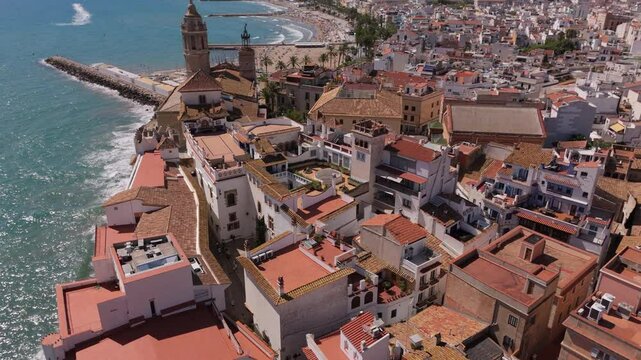 Aerial view of Sitges coastal village and Iglesia de San Bartolome y Santa Tecla during a sunny day