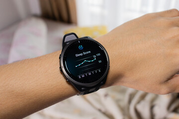 Smartwatch is being used as a sleep tracker with bed in the background. After edits.