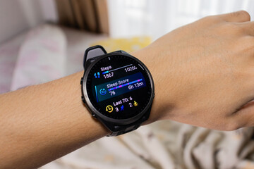 Smartwatch is being used as a sleep tracker with bed in the background. After edits.