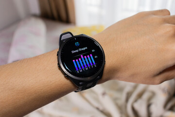Smartwatch is being used as a sleep tracker with bed in the background. After edits.