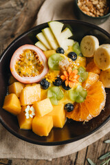 High angle view of smoothie bowl with fresh fruits on top in plate on table