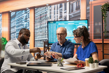 Mature couple discussing pension plans with a financial planner, focusing on long term financial security and investment opportunity. Consulting an advisor about their retirement strategy.
