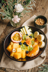 High angle view of smoothie bowl with fresh fruits on top in plate on table