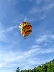 Colorful Hot Air Balloon on Blue Sky Flying Over Green Trees