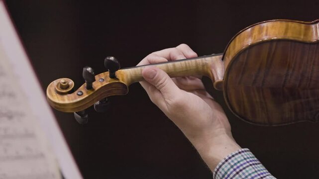 Close up of a musician's hands playing the violin
