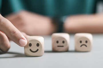 Person rating customer satisfaction online on wooden block for feedback survey concept. feedback...