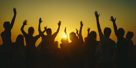 Fototapeta premium Group of people raising hands at golden sunset