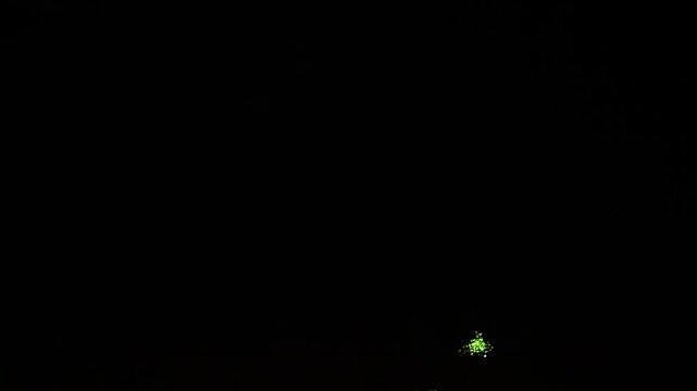 Gold pink blue green sparks scattering fireworks on black night sky. General plan