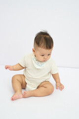 Fototapeta premium A Baby Sitting on the Floor with saliva towels under the chin