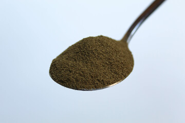 One spoon of moringa powder, isolated on white background