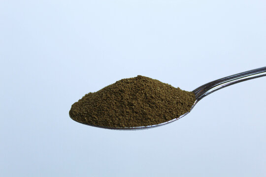 One spoon of moringa powder, isolated on white background