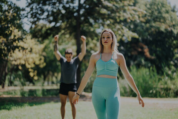 A serene moment captured as two friends engage in fitness activities in a park, highlighting relaxation, friendship, and the tranquility of outdoor exercise.