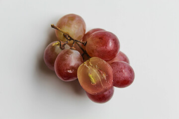 Group of red purple greenish grape cluster with stem, halved cut, isolated on white background