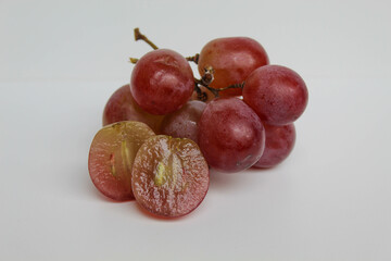 Group of red purple greenish grape cluster with stem, halved cut, isolated on white background