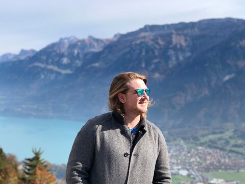Man in grey zip up jacket standing on mountain