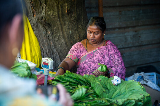 A lady selling betel leaf at her store.