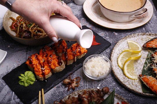 A table of Japanese cuisine consisting of sushi rolls noodles sea products