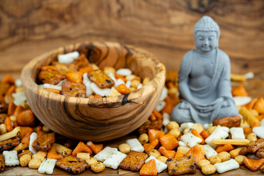 Different types of Japanese rice cakes on olive wood with buddha statue