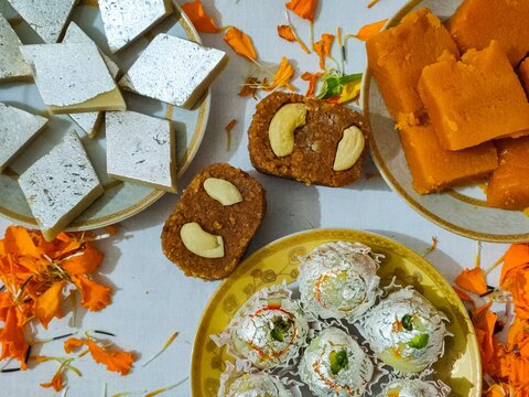 Indian sweets on white ceramic plates
