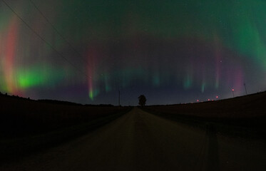 Aurora in the night sky over a rural landscape