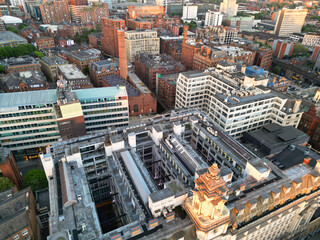 Fototapeta premium Aerial View of Greater Manchester City Centre and Tall Buildings During Golden Hour of Sunset, England UK. High Angle View Was Captured with Drone's Camera on the day of May 5th, 2024
