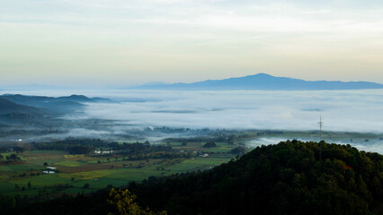 Fototapeta premium Landscape of a rural village on the mountainside in the morning with a sea of ​​fog covering it.