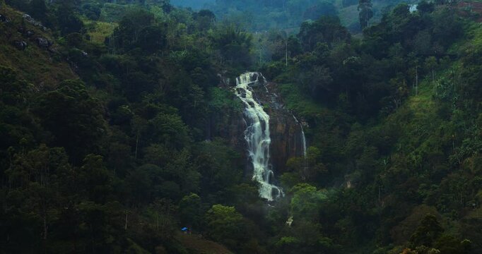 Footage of the stunning Kuda Ravana Ella waterfall, nestled in the lush Sri Lankan forest, cascading down rock formations. Perfect for showcasing natural beauty and travel inspiration.