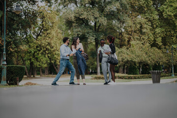 Obraz premium A diverse group of business people engage in a lively conversation while standing in a scenic park, surrounded by lush greenery, embodying collaboration and teamwork in a relaxed environment.